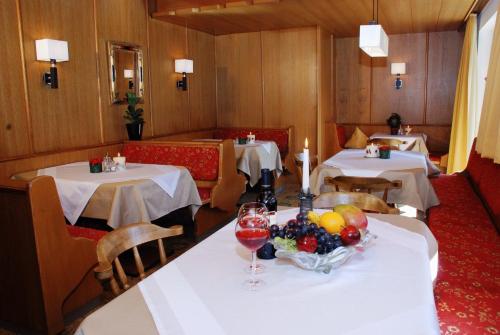 a restaurant with two tables with wine glasses and fruit at Apart-Garni Alpevita in Mayrhofen