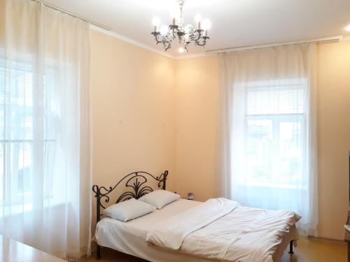 リヴィウにあるArmenian Kvartalのベッドルーム1室(白いシーツとシャンデリア付)