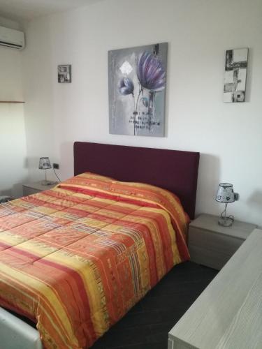 a bedroom with a bed with a colorful blanket at Monti di bò in Aggius