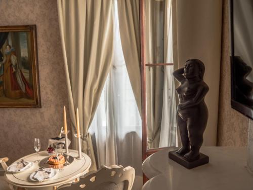 a table with a statue of a little girl on it at EGO' Boutique Hotel - The Silk Road in Venice