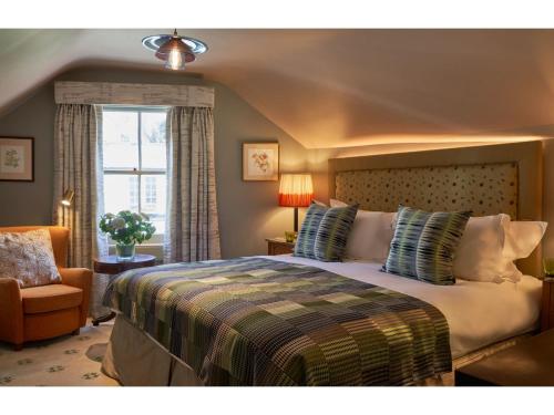 a bedroom with a bed and a chair and a window at Oppulent Lansdown Crescent Mews House with Free parking - Pass the Keys in Bath