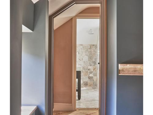a door with a mirror in a hallway at Oppulent Lansdown Crescent Mews House with Free parking - Pass the Keys in Bath