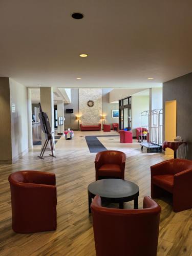 a lobby with couches and a table and chairs at Ramada by Wyndham Belleville Harbourview Conference Center in Belleville