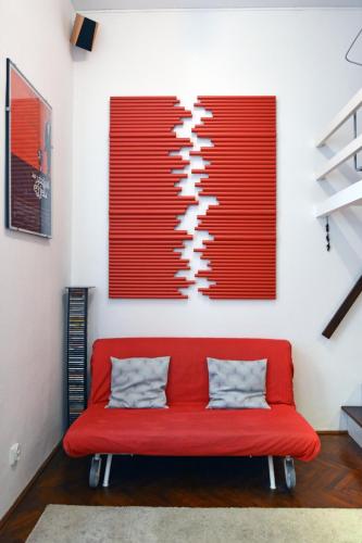 un divano rosso in una stanza con le tende rosse di Peace Place a Budapest