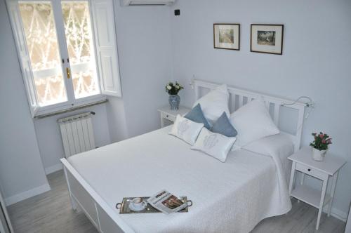 biała sypialnia z białym łóżkiem i oknem w obiekcie The Avalon w Rzymie