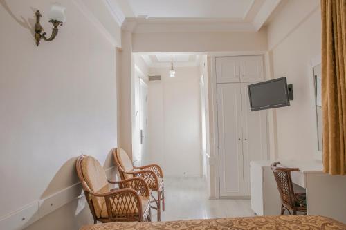 a room with three chairs and a tv on the wall at Hali Hotel in Istanbul