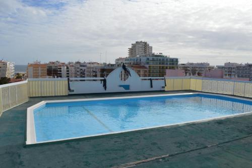 a large swimming pool on the roof of a building at Apartamento Eden in Monte Gordo
