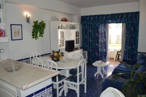 a kitchen and living room with a table and chairs at Apartamento Eden in Monte Gordo