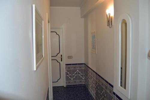 korytarzem ze schodami i podłogą wyłożoną kafelkami w obiekcie Apartamento Eden w mieście Monte Gordo
