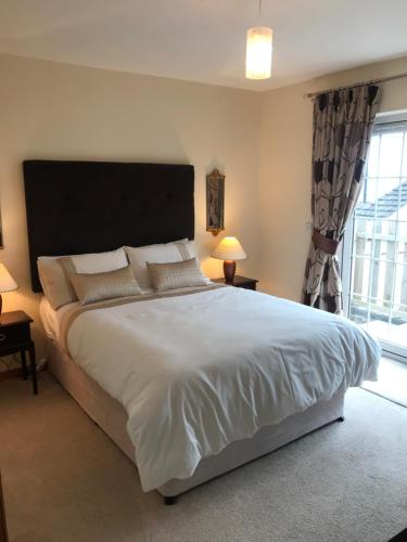 a bedroom with a large bed and a large window at Lindfields in Inverness