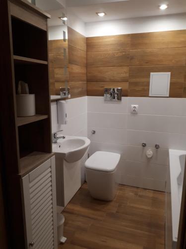 La salle de bains est pourvue de toilettes et d'un lavabo. dans l'établissement Małe przytulne mieszkanie, à Mrągowo