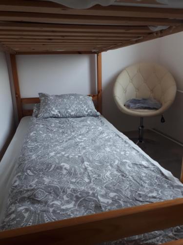 - un lit et une chaise dans une chambre dans l'établissement Małe przytulne mieszkanie, à Mrągowo