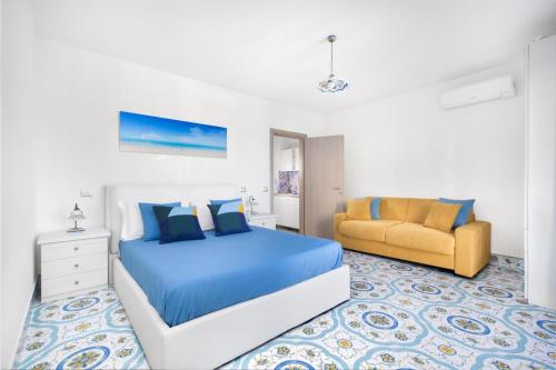ein Schlafzimmer mit einem blauen Bett und einem gelben Stuhl in der Unterkunft Millie Sorrento Suites in Sorrent