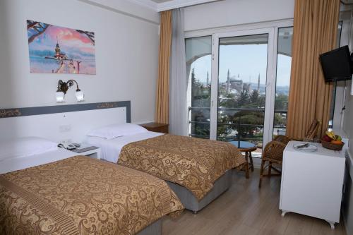 ein Hotelzimmer mit 2 Betten und einem Fenster in der Unterkunft Hali Hotel in Istanbul