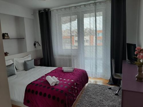 ein Schlafzimmer mit einem Bett mit zwei Handtüchern darauf in der Unterkunft Chic Apartament in Deva