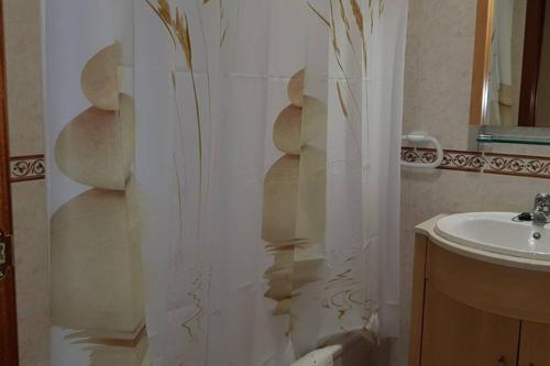 y baño con cortina de ducha y lavamanos. en Villa MIAMI PLAYA EN ESPAGNE, en Miami Platja