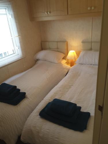 two twin beds in a room with a window at Annandale skegness in Skegness