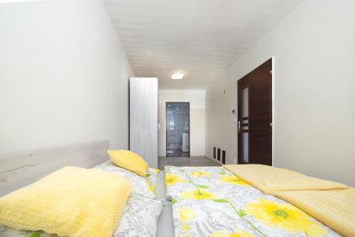 Un dormitorio con una cama con almohadas amarillas. en Apartman MANDALA en Banská Bystrica