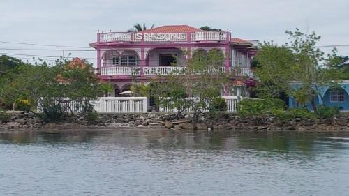 a pink house on the shore of a body of water at Beya Suites in Punta Gorda