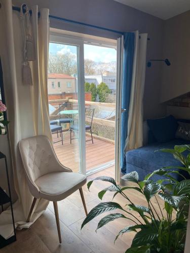 a room with a chair and a sliding glass door at Pod Beczką in Augustów