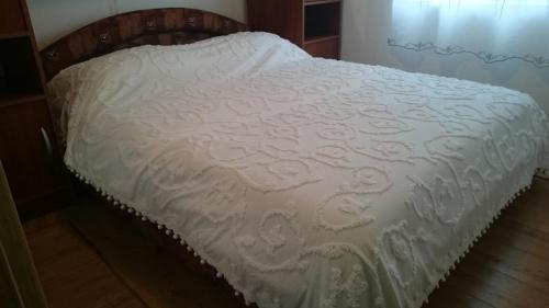 ein Bett mit einer weißen Bettdecke in einem Schlafzimmer in der Unterkunft Holiday house near the see in Luka