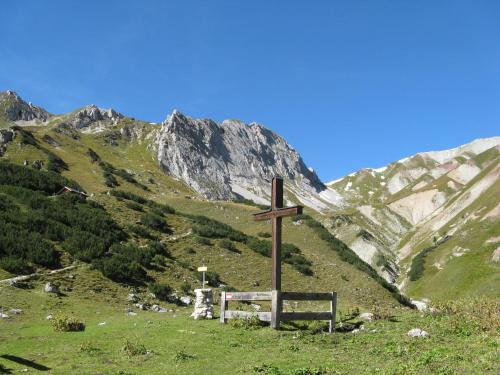 a cross on a hill with mountains in the background at Appartements Schneezauber in Lermoos