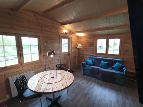 uma sala de estar com uma mesa e um sofá em Gîtes entre mer et campagne, 3km de Berck les chalets du Fliers em Berck