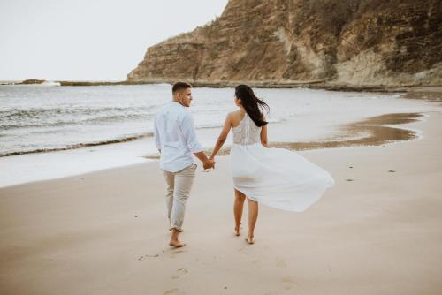 a bride and groom walking on the beach at TreeCasa Hotel & Resort Nicaragua in San Juan del Sur
