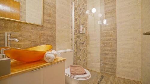 y baño con lavabo de color naranja y aseo. en Prime Residence en Braşov