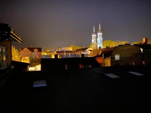 a view of a city at night with a church at Pod Beczką in Augustów