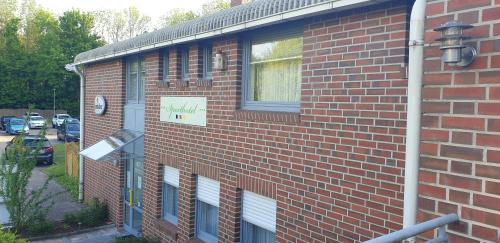 a brick building with a sign on the side of it at Sporthotel Papenburg in Papenburg