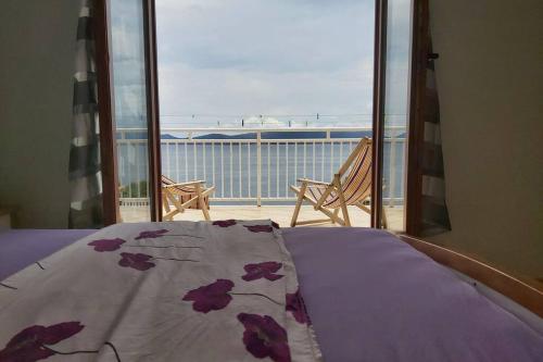 Un dormitorio con una cama con vista al mar. en Beautiful apartment 80 m from the sea, en Marusici 