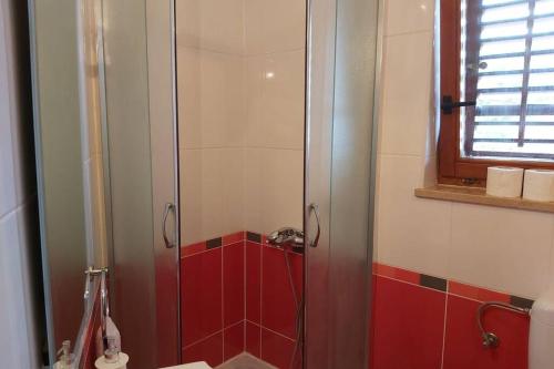 y baño con ducha de azulejos rojos. en Beautiful apartment 80 m from the sea, en Marusici 