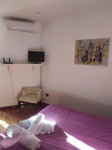 - une chambre avec un lit violet et une chaise dans l'établissement La Più Bella in Old Town, à Bari