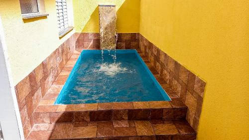 einen Pool mit einem Brunnen in einem Zimmer in der Unterkunft Aquamarine House in Itanhaém