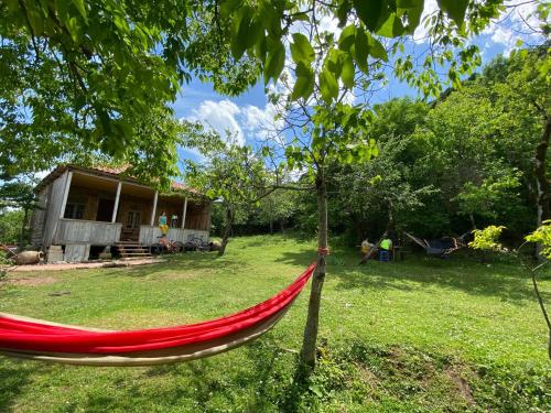 a red hammock in front of a house at Sveri Adventure Camp in Chiatʼura