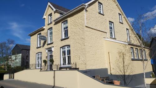 a large brick building with windows on a street at Riverbank Bed and Breakfast in Llanwrtyd Wells