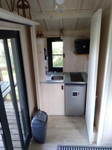a small kitchen in a tiny house with a sink at Les Lodges de Phanou in Prissac