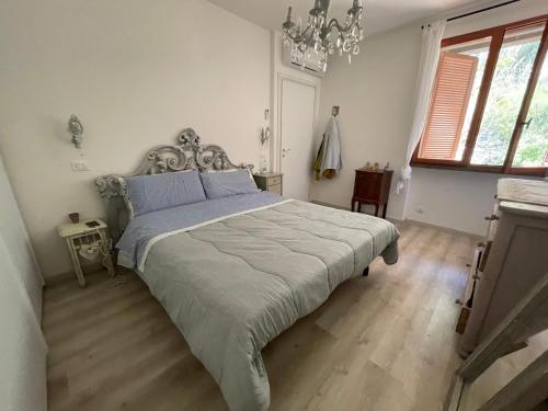 um quarto com uma cama e um lustre em VerdeMare em Rio nellʼElba