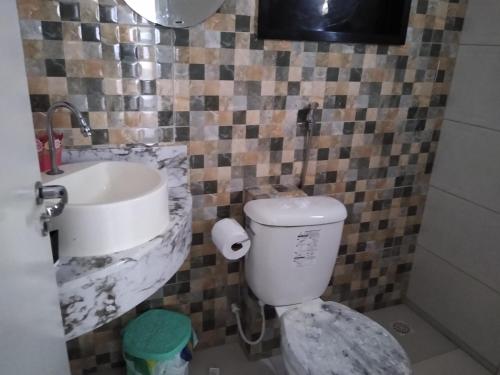 a bathroom with a toilet and a sink at Apartamentos aconchegantes in Teresina