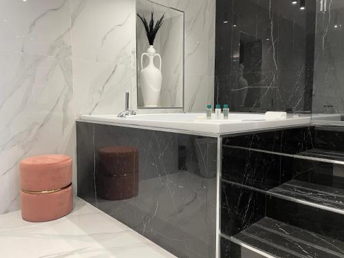 a black and white bathroom with a sink and a mirror at 4heavens_naples in Naples