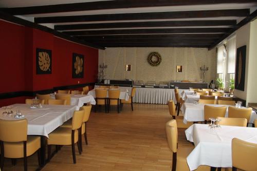 a dining room with white tables and yellow chairs at Stadt-Gut-Hotel Zum Rathaus in Oberhausen