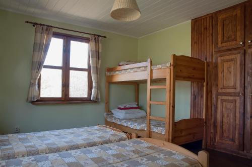 - une chambre avec 2 lits superposés et une fenêtre dans l'établissement Dom nad Strugą, à Słuchowo