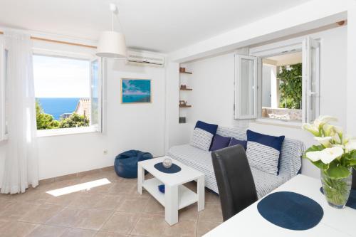 een woonkamer met een bank en een tafel bij Apartments Krmek in Dubrovnik