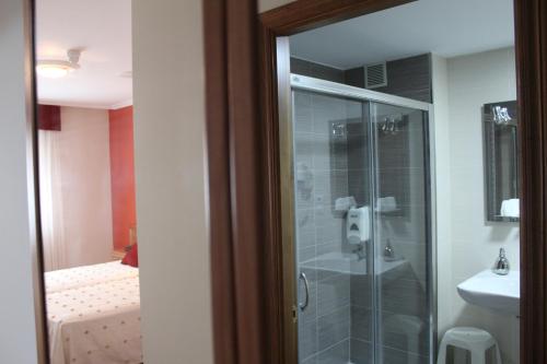 a bathroom with a shower and a toilet and a sink at Hotel Rego Foz in Foz