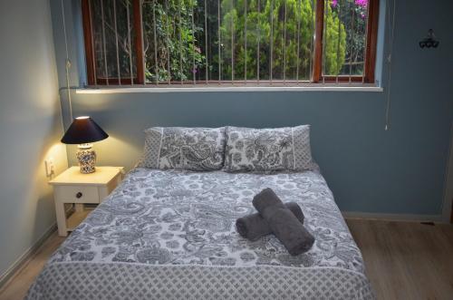 un osito de peluche tirado en una cama en un dormitorio en Seaforth Beach Apartment, en Ciudad del Cabo