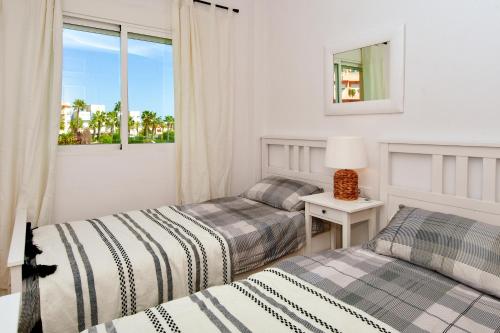 two beds in a room with a window at Apartamento Terrazas de Aguamarina in Orihuela Costa