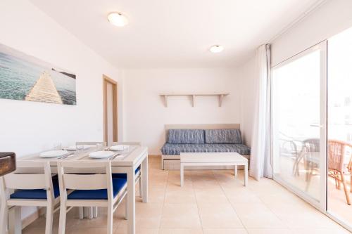 a living room with a table and chairs at Apartamentos Avenida - MC Apartamentos Ibiza in Ibiza Town