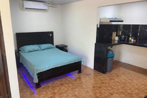 um quarto com uma cama num quarto com luzes azuis em Comodo Departamento full equipado con cocina, TV 80p, wifi 150mbs, etc em Paquera