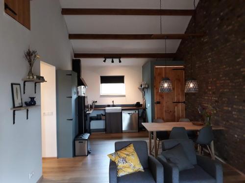 a kitchen and living room with a table and chairs at In de 7e Hemel in Grashoek